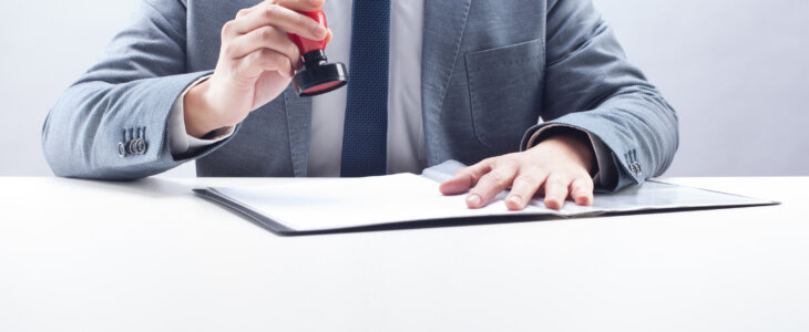 Businessman stamping the document at the desk.